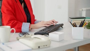 Secretary welcoming a client at the reception desk of an audit firm